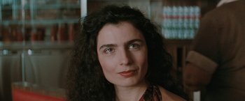 Movie still from “The Adjuster” (1991), directed by Atom Egoyan – A person with long curly hair; Close Up shot, High angle