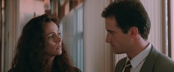 Movie still from “The Adjuster” (1991), directed by Atom Egoyan – A man and a woman looking at one another; Close Up shot, Over the shoulder angle