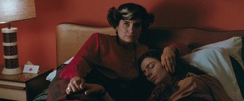 Movie still from “The Adjuster” (1991), directed by Atom Egoyan – A woman sitting next to a man on a couch; Close Up shot, High angle