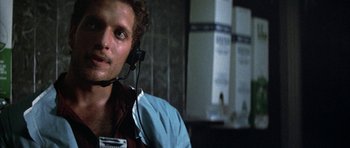 Movie still from “The Adventures of Buckaroo Banzai Across the 8th Dimension” (1984), directed by W.D. Richter – A man wearing a headset in a dark room; Close Up shot, Low angle