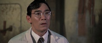 Movie still from “The Adventures of Buckaroo Banzai Across the 8th Dimension” (1984), directed by W.D. Richter – A man in a white lab coat wearing glasses; Close Up shot, Low angle