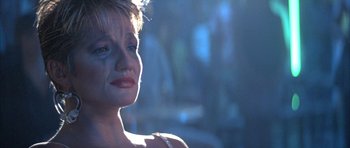 Movie still from “The Adventures of Buckaroo Banzai Across the 8th Dimension” (1984), directed by W.D. Richter – A person wearing a necklace; Close Up shot, Over the shoulder angle