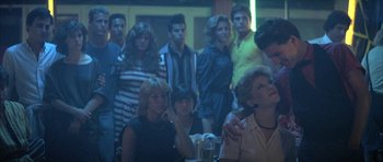 Movie still from “The Adventures of Buckaroo Banzai Across the 8th Dimension” (1984), directed by W.D. Richter – A group of people standing in a room; Medium shot, Over the shoulder angle