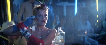 Movie still from “The Adventures of Buckaroo Banzai Across the 8th Dimension” (1984), directed by W.D. Richter – A woman with makeup on her face is sitting at a table; Close Up shot, Low angle