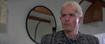 Movie still from “The Adventures of Buckaroo Banzai Across the 8th Dimension” (1984), directed by W.D. Richter – A man with blonde hair stares into a mirror; Close Up shot, Low angle