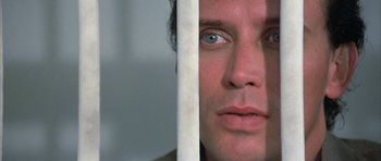 Movie still from “The Adventures of Buckaroo Banzai Across the 8th Dimension” (1984), directed by W.D. Richter – A person behind a fence; Close Up shot, Low angle