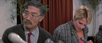 Movie still from “The Adventures of Buckaroo Banzai Across the 8th Dimension” (1984), directed by W.D. Richter – A man with a mustache and a tie; Close Up shot, Over the shoulder angle
