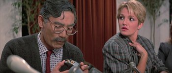 Movie still from “The Adventures of Buckaroo Banzai Across the 8th Dimension” (1984), directed by W.D. Richter – An older man and a younger woman looking at a cell phone; Close Up shot, Over the shoulder angle