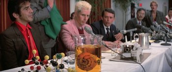 Movie still from “The Adventures of Buckaroo Banzai Across the 8th Dimension” (1984), directed by W.D. Richter – A man and a woman sitting in front of a table; Close Up shot, Over the shoulder angle