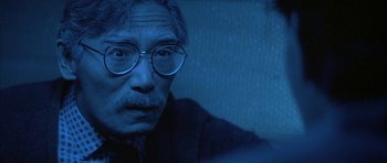 An older man wearing glasses looking at the camera