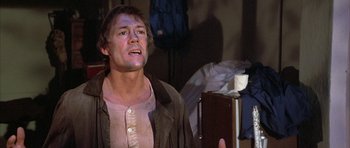 Movie still from “The Adventures of Buckaroo Banzai Across the 8th Dimension” (1984), directed by W.D. Richter – A man is standing in a messy room; Close Up shot, Low angle
