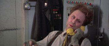 Movie still from “The Adventures of Buckaroo Banzai Across the 8th Dimension” (1984), directed by W.D. Richter – A man in a tie is talking on the phone; Close Up shot, Over the shoulder angle