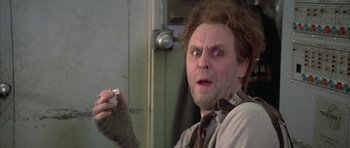 Movie still from “The Adventures of Buckaroo Banzai Across the 8th Dimension” (1984), directed by W.D. Richter – A person holding something in his hand; Close Up shot, Low angle