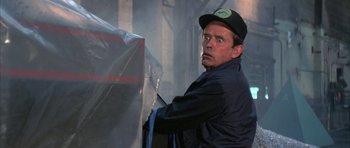 Movie still from “The Adventures of Buckaroo Banzai Across the 8th Dimension” (1984), directed by W.D. Richter – A man wearing a black hat and a blue jacket; Close Up shot, Low angle