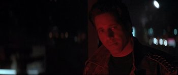 Movie still from “The Adventures of Ford Fairlane” (1990), directed by Renny Harlin – A person in a dark room; Close Up shot, Low angle