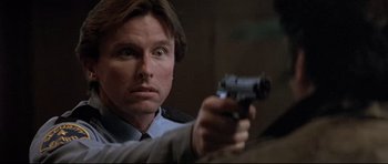 Movie still from “The Adventures of Ford Fairlane” (1990), directed by Renny Harlin – A person holding a gun; Close Up shot, Low angle