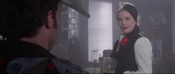 Movie still from “The Adventures of Ford Fairlane” (1990), directed by Renny Harlin – A man and a woman are standing in front of a window; Close Up shot, Over the shoulder angle