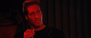 Movie still from “The Adventures of Ford Fairlane” (1990), directed by Renny Harlin – A man holding a cigarette in his mouth; Close Up shot, Low angle