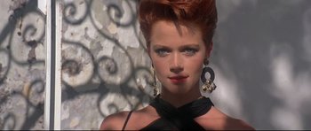 Movie still from “The Adventures of Ford Fairlane” (1990), directed by Renny Harlin – A woman with red hair wearing a black dress; Close Up shot, Low angle