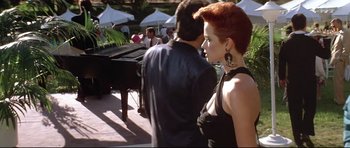 Movie still from “The Adventures of Ford Fairlane” (1990), directed by Renny Harlin – A man and a woman standing in front of a piano; Medium shot, Over the shoulder angle