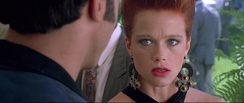 Movie still from “The Adventures of Ford Fairlane” (1990), directed by Renny Harlin – A person wearing a suit and tie; Close Up shot, Over the shoulder angle