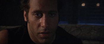 Movie still from “The Adventures of Ford Fairlane” (1990), directed by Renny Harlin – A man's face in a dark room; Close Up shot, Low angle