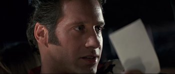 Movie still from “The Adventures of Ford Fairlane” (1990), directed by Renny Harlin – A man's face as he looks into the distance; Close Up shot, Over the shoulder angle
