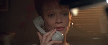 Movie still from “The Adventures of Ford Fairlane” (1990), directed by Renny Harlin – A person talking on a phone; Close Up shot, Low angle