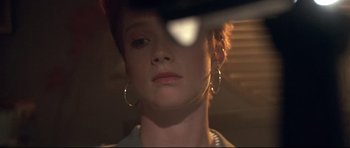 Movie still from “The Adventures of Ford Fairlane” (1990), directed by Renny Harlin – A person wearing a pair of earrings; Close Up shot, Low angle