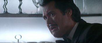 Movie still from “The Adventures of Ford Fairlane” (1990), directed by Renny Harlin – A person wearing a suit and tie; Close Up shot, Low angle