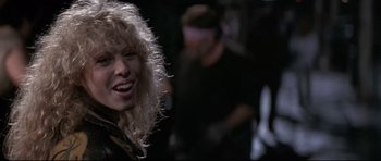 Movie still from “The Adventures of Ford Fairlane” (1990), directed by Renny Harlin – A person with long blonde hair; Close Up shot, Low angle