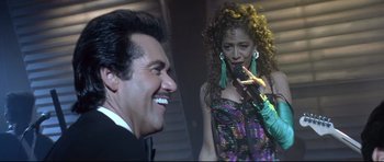 Movie still from “The Adventures of Ford Fairlane” (1990), directed by Renny Harlin – A man and a woman are talking to each other; Medium shot, Low angle