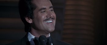 Movie still from “The Adventures of Ford Fairlane” (1990), directed by Renny Harlin – A person wearing a suit and tie; Close Up shot, Low angle