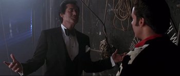 Movie still from “The Adventures of Ford Fairlane” (1990), directed by Renny Harlin – A man wearing a tuxedo and a bow tie; Medium shot, Low angle