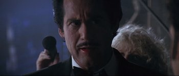 Movie still from “The Adventures of Ford Fairlane” (1990), directed by Renny Harlin – A person wearing a suit and tie; Close Up shot, Low angle