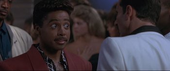 Movie still from “The Adventures of Ford Fairlane” (1990), directed by Renny Harlin – A man looking at another man in a crowd; Close Up shot, Over the shoulder angle