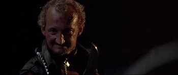 Movie still from “The Adventures of Ford Fairlane” (1990), directed by Renny Harlin – A person with a knife in his mouth; Close Up shot, Low angle