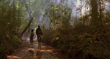 Movie still from “The Adventures of Huck Finn” (1993), directed by Stephen Sommers – A man and a child walking through the woods; Extreme Wide shot, Low angle