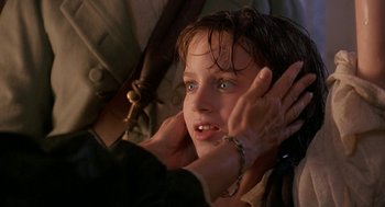 Movie still from “The Adventures of Huck Finn” (1993), directed by Stephen Sommers – A young girl with a rosary around her neck; Close Up shot, Over the shoulder angle