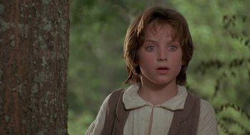 Movie still from “The Adventures of Huck Finn” (1993), directed by Stephen Sommers – A young girl with blue eyes standing next to a tree; Close Up shot, Over the shoulder angle