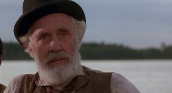 Movie still from “The Adventures of Huck Finn” (1993), directed by Stephen Sommers – An old man with a beard wearing a black hat; Close Up shot, Over the shoulder angle