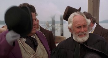 Movie still from “The Adventures of Huck Finn” (1993), directed by Stephen Sommers – Two men standing next to each other near a body of water; Close Up shot, Over the shoulder angle