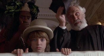 Movie still from “The Adventures of Huck Finn” (1993), directed by Stephen Sommers – A young boy with a hat and a beard; Close Up shot, Low angle