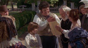 Movie still from “The Adventures of Huck Finn” (1993), directed by Stephen Sommers – Two men and a boy looking at a piece of paper; Medium shot, Over the shoulder angle