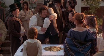 Movie still from “The Adventures of Huck Finn” (1993), directed by Stephen Sommers – A couple of people that are kissing in front of a table; Medium shot, Over the shoulder angle