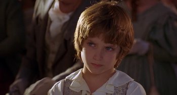 Movie still from “The Adventures of Huck Finn” (1993), directed by Stephen Sommers – A young boy is looking into the camera; Close Up shot, Over the shoulder angle