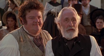 Movie still from “The Adventures of Huck Finn” (1993), directed by Stephen Sommers – A man and a woman standing next to each other in front of a crowd; Close Up shot, Low angle