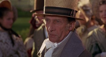 Movie still from “The Adventures of Huck Finn” (1993), directed by Stephen Sommers – An old man wearing a straw hat and a coat; Close Up shot, Over the shoulder angle