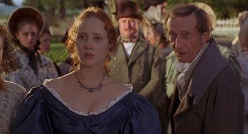 Movie still from “The Adventures of Huck Finn” (1993), directed by Stephen Sommers – A woman in a blue dress standing in front of a group of people; Close Up shot, Over the shoulder angle