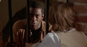 Movie still from “The Adventures of Huck Finn” (1993), directed by Stephen Sommers – A man looking at a woman through a fence; Close Up shot, Over the shoulder angle